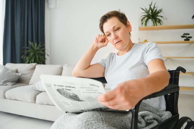 Vrouw van middelbare leeftijd die op rolstoel zit