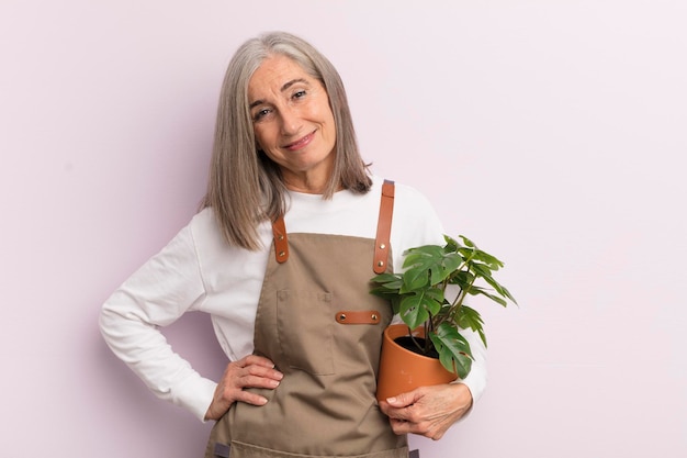 Vrouw van middelbare leeftijd die vrolijk lacht met een hand op de heup en zelfverzekerd boerenconcept