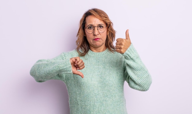 Foto vrouw van middelbare leeftijd die zich verward, geen idee en onzeker voelt, het goede en het slechte afwegend in verschillende opties of keuzes