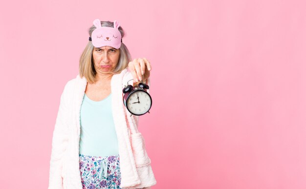 Foto vrouw van middelbare leeftijd dragen nacht pak met een wekker