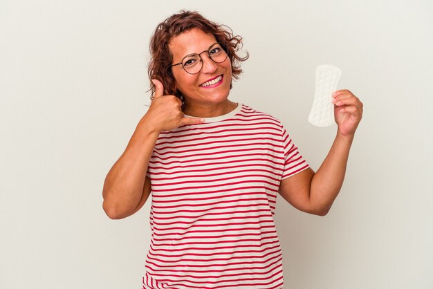 Vrouw van middelbare leeftijd met een kompres geïsoleerd op een witte achtergrond met een mobiel telefoongesprek gebaar met vingers.