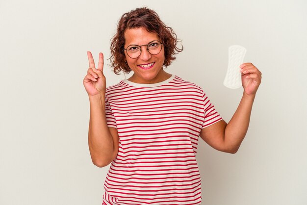 Vrouw van middelbare leeftijd met een kompres geïsoleerd op een witte achtergrond met nummer twee met vingers.