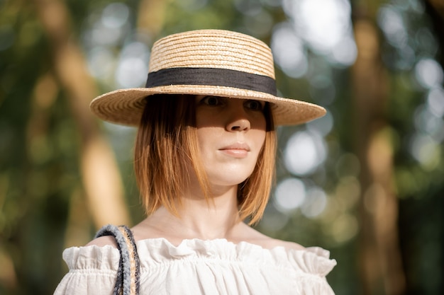 Vrouw van middelbare leeftijd met een strohoed in het bos