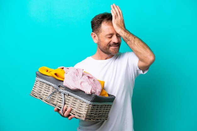 Vrouw van middelbare leeftijd met een wasmand geïsoleerd op blauwe achtergrond heeft iets gerealiseerd en de oplossing voor ogen