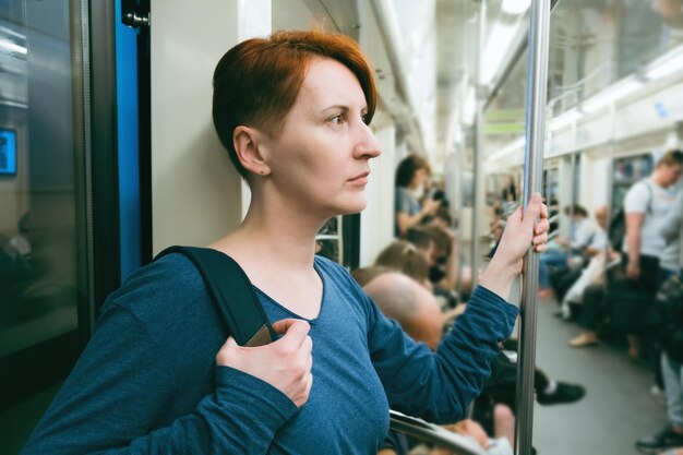 Foto vrouw van middelbare leeftijd met kort haar rijdt in een metro