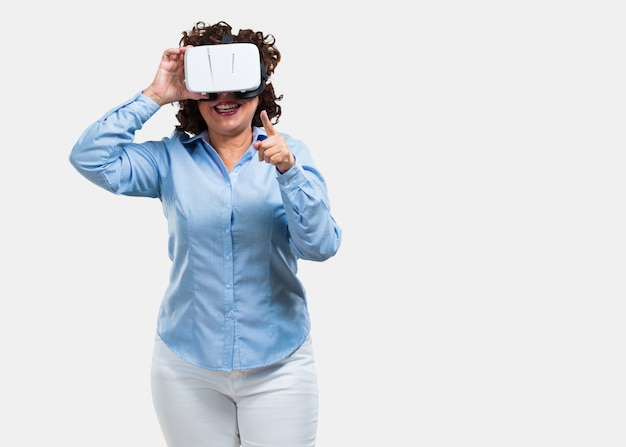 Vrouw van middelbare leeftijd opgewonden en vermaakt, spelen met virtual reality-bril