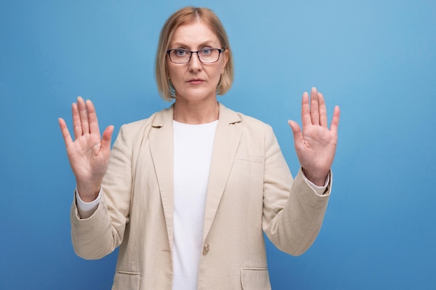 Vrouw van middelbare leeftijd serieus op heldere studioachtergrond met kopieerruimte