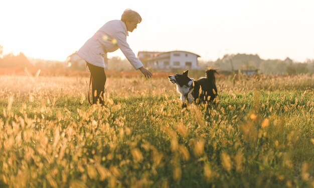 Vrouw van middelbare leeftijd spelen met haar border collie hond