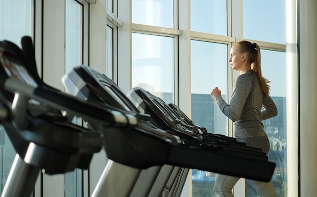 Vrouw van middelbare leeftijd trainen in de sportschool. Gezonde levensstijl. Trainen op een hometrainer.