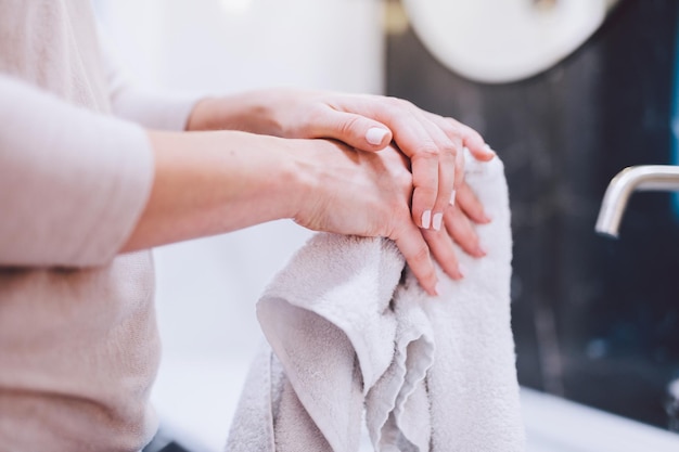 Vrouw veegt handen in handdoek af na het wassen Hygiëne