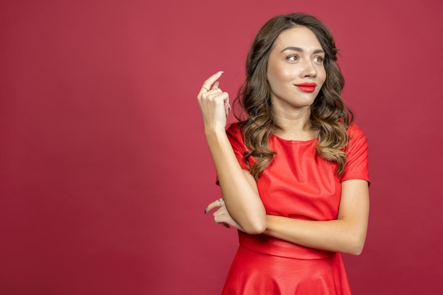 Vrouw verbijsterd glimlachend op een rode achtergrond