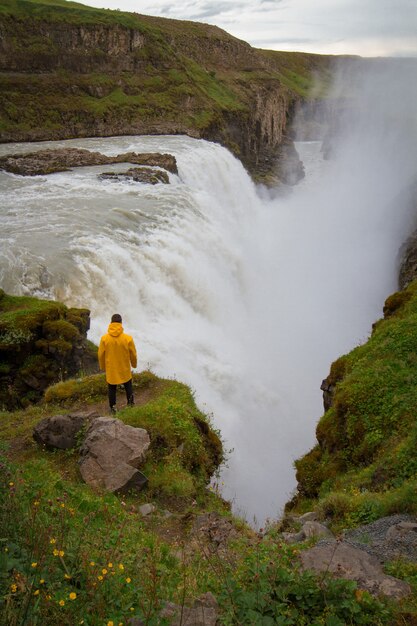 Vrouw verblijf op waterval in ijsland verberg waterval in ijsland a