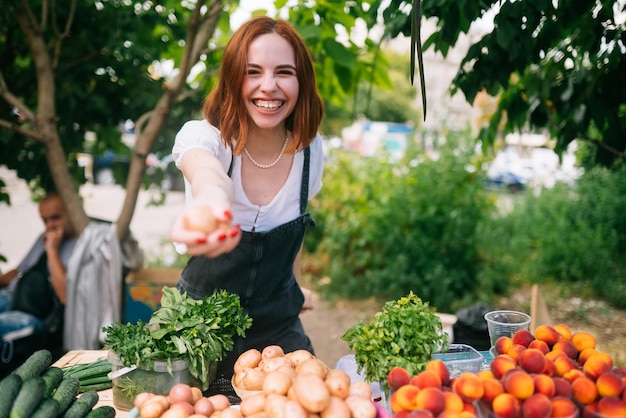 Vrouw verkoper aan de balie met groenten Klein bedrijfsconcept