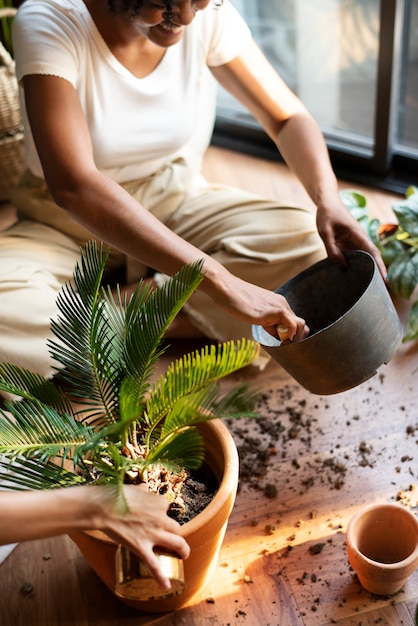 Vrouw verpot planten in het nieuwe normaal