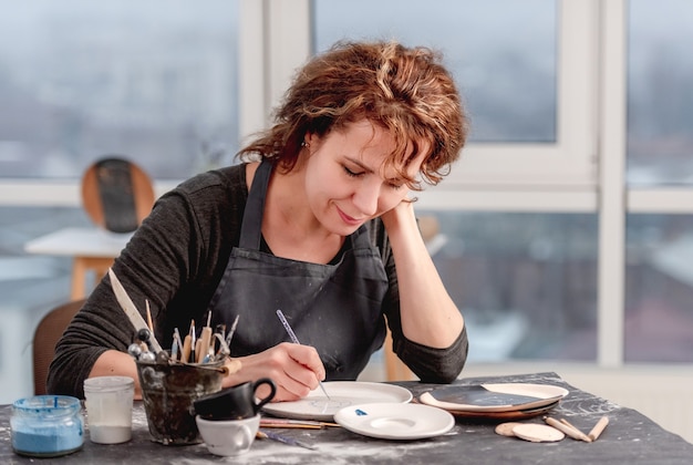 Vrouw versieren bord met handgemaakt patroon