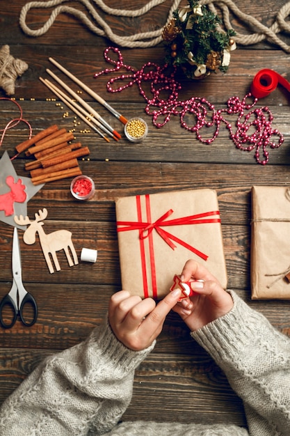 Vrouw versieren doos met kerstcadeaus