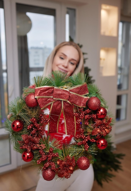 Vrouw versiert huis voor kerstvakantie kerstkrans zelf gemaakte zachte focus