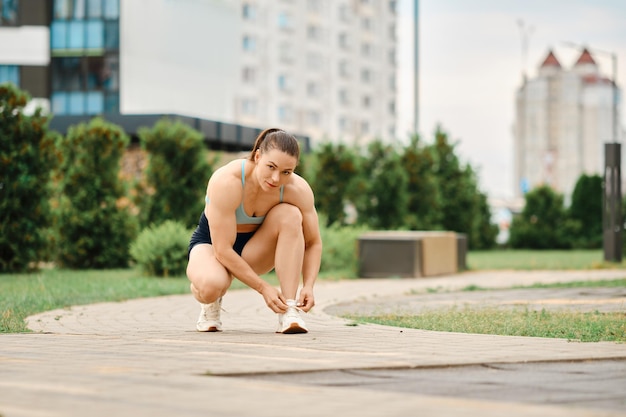 Vrouw veters strikken op weg naar sportveld