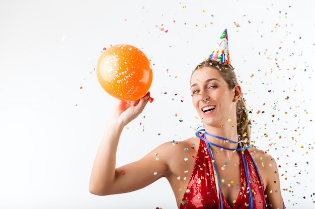 Vrouw viert verjaardag bij een douche van confetti met ballon