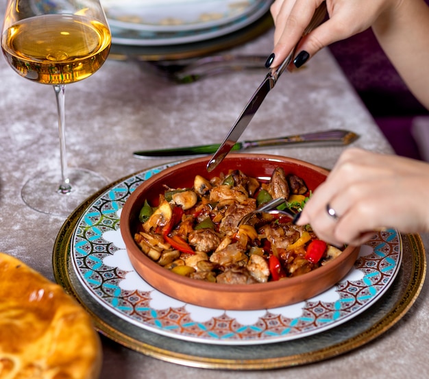 Vrouw vlees eten met witte wijn in het restaurant