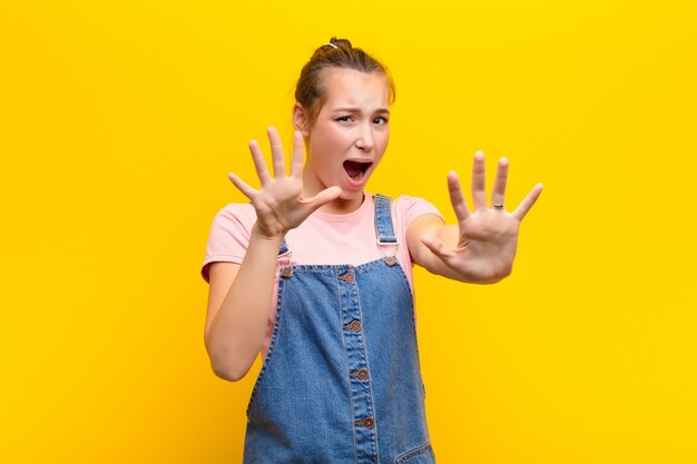 vrouw voelt zich doodsbang, trekt zich terug en schreeuwt van angst en paniek, reagerend op een nachtmerrie