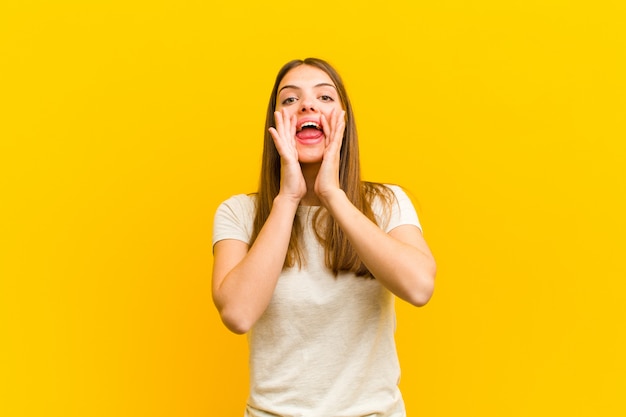 vrouw voelt zich gelukkig, opgewonden en positief, schreeuwt het uit met handen naast de mond en roept