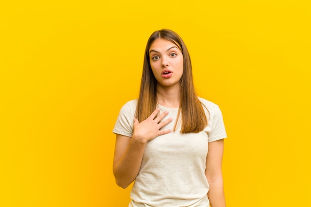 vrouw voelt zich geschokt, verbaasd en verrast, met de hand op de borst en open mond en zegt wie, mij?