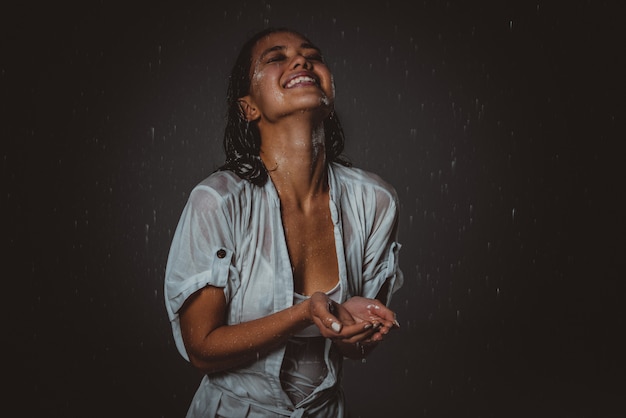 Vrouw voelt zich goed en vrij onder de zomerregen