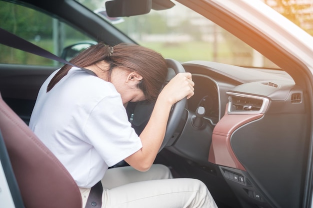 Vrouw voelt zich stress en boos tijdens lange tijd auto rijden Aziatisch meisje moe en vermoeid met hoofdpijn stop na auto rijden in verkeersopstopping Slaperig uitrekkend en dronken concept