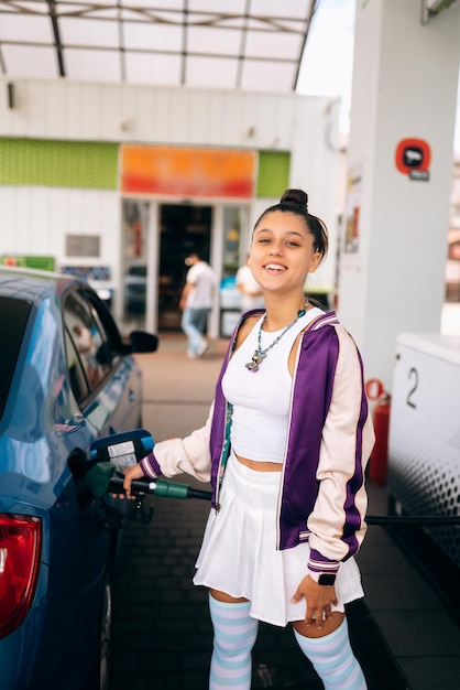 Vrouw vult haar auto met brandstof bij een benzinestation