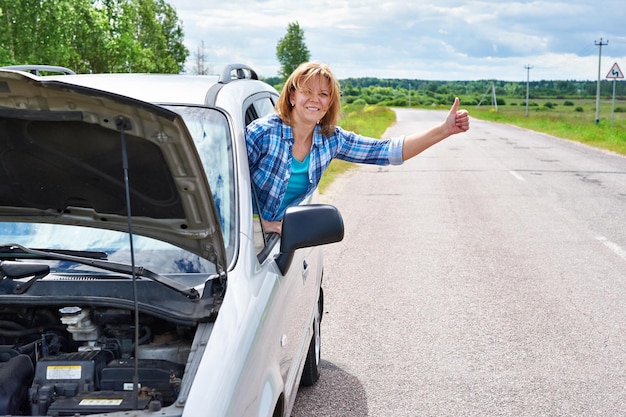 Vrouw wachten om te helpen en duimen van auto