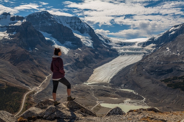Vrouw wandelaar staande op Wilcox piek uitkijkend over de Columbia icefields en de Athabasca gletsjer, in Jasper, Alberta, Canada