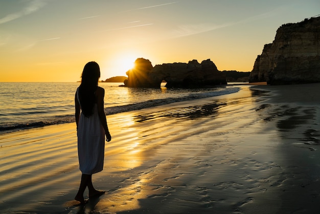 Vrouw wandelen door het strand van de kust in de Algarve, Portugal