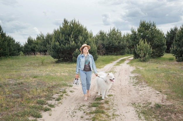 Vrouw wandelen met hond op de natuur buiten de stad