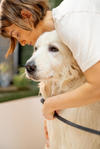 Vrouw wast haar hond thuis in bad