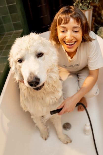 Vrouw wast haar hond thuis in bad