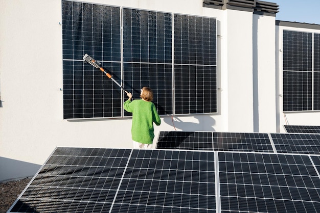 Vrouw wast zonnepanelen op het dak