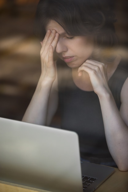 Foto vrouw wat betreft haar voorhoofd