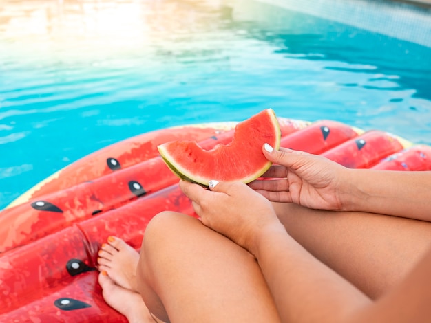 Vrouw watermeloen eten in een zwembad