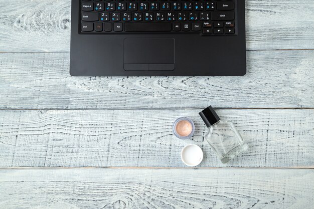 vrouw werkplek met laptop, parfum en cosmetica