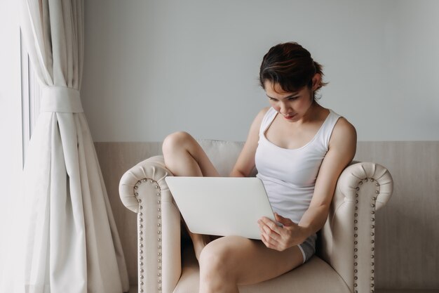 Vrouw werkt en ontspant met laptop op het bankconcept werk van hotel