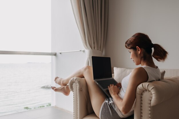 Vrouw werkt en ontspant met laptop op het bankconcept werk van hotel