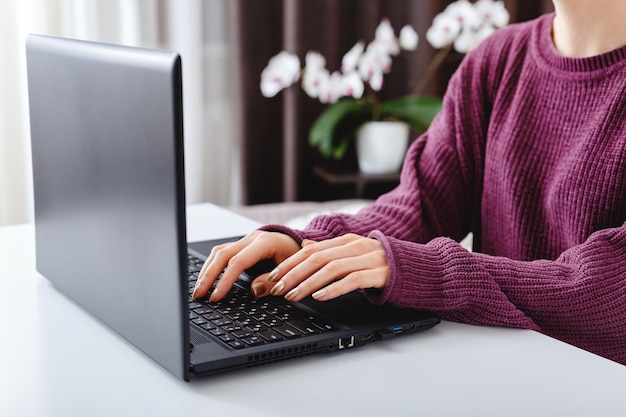 Vrouw werkt of leert vanuit huis met behulp van laptop.