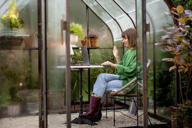 Vrouw werkt op afstand op laptop in tuin