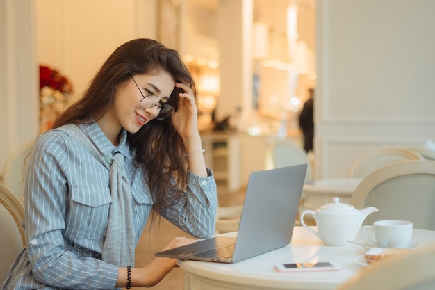 Vrouw werkt op de pc in het internetcafé