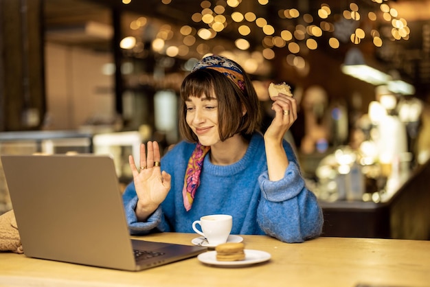 Vrouw werkt op laptop in coffeeshop