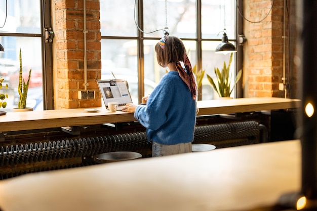 Vrouw werkt op laptop in coffeeshop