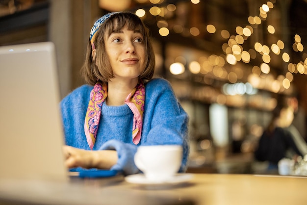 Vrouw werkt op laptop in coffeeshop