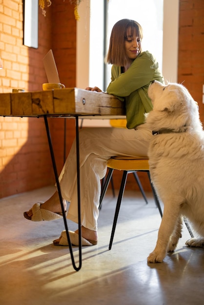 Vrouw werkt op laptop met hond in gezellige woonkamer