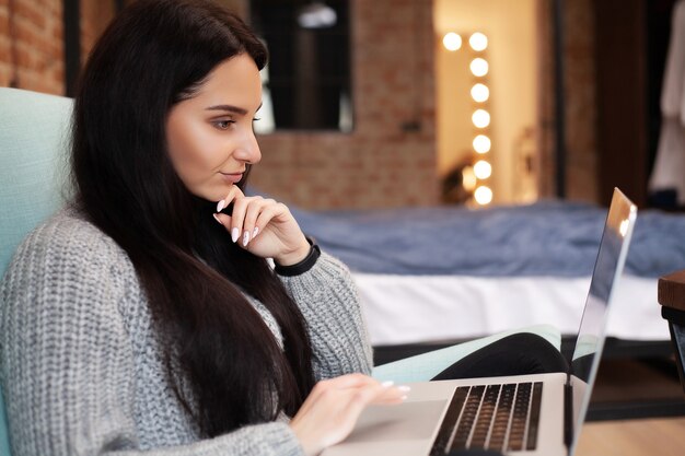 Vrouw werkt thuis op een laptop tijdens een wereldwijde virusepidemie.